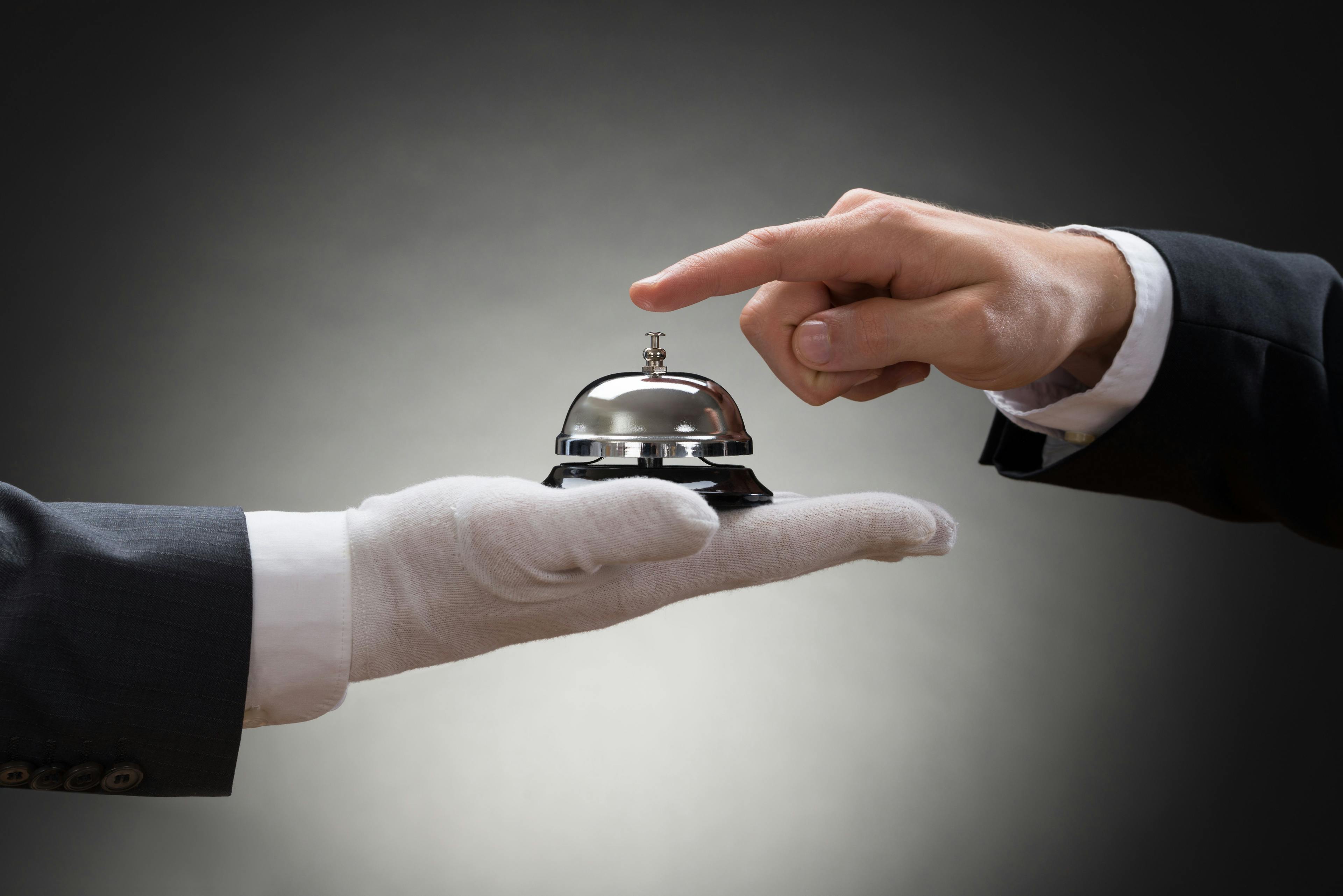white glove holding bell concierge concept 