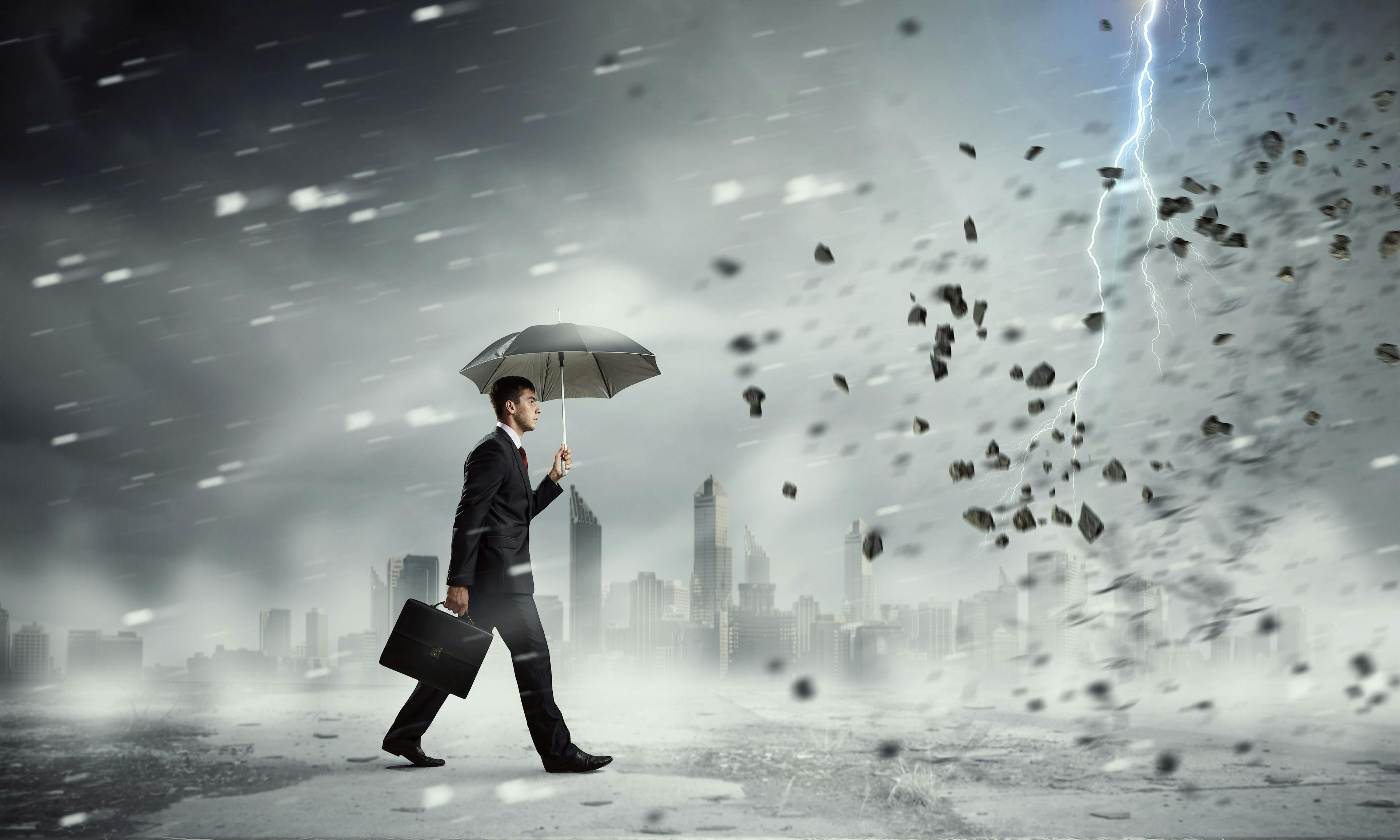 business man walking through a storm with an umbrella