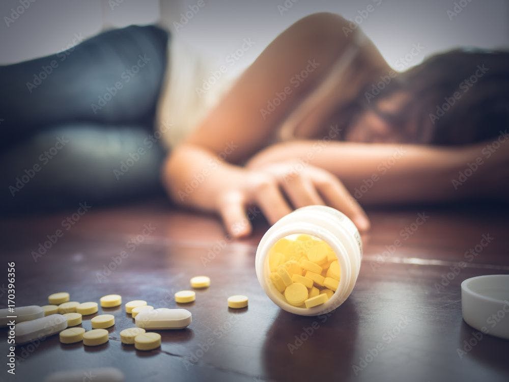 Dead woman next to bottle of pills ©Siam-stock.adobe.com