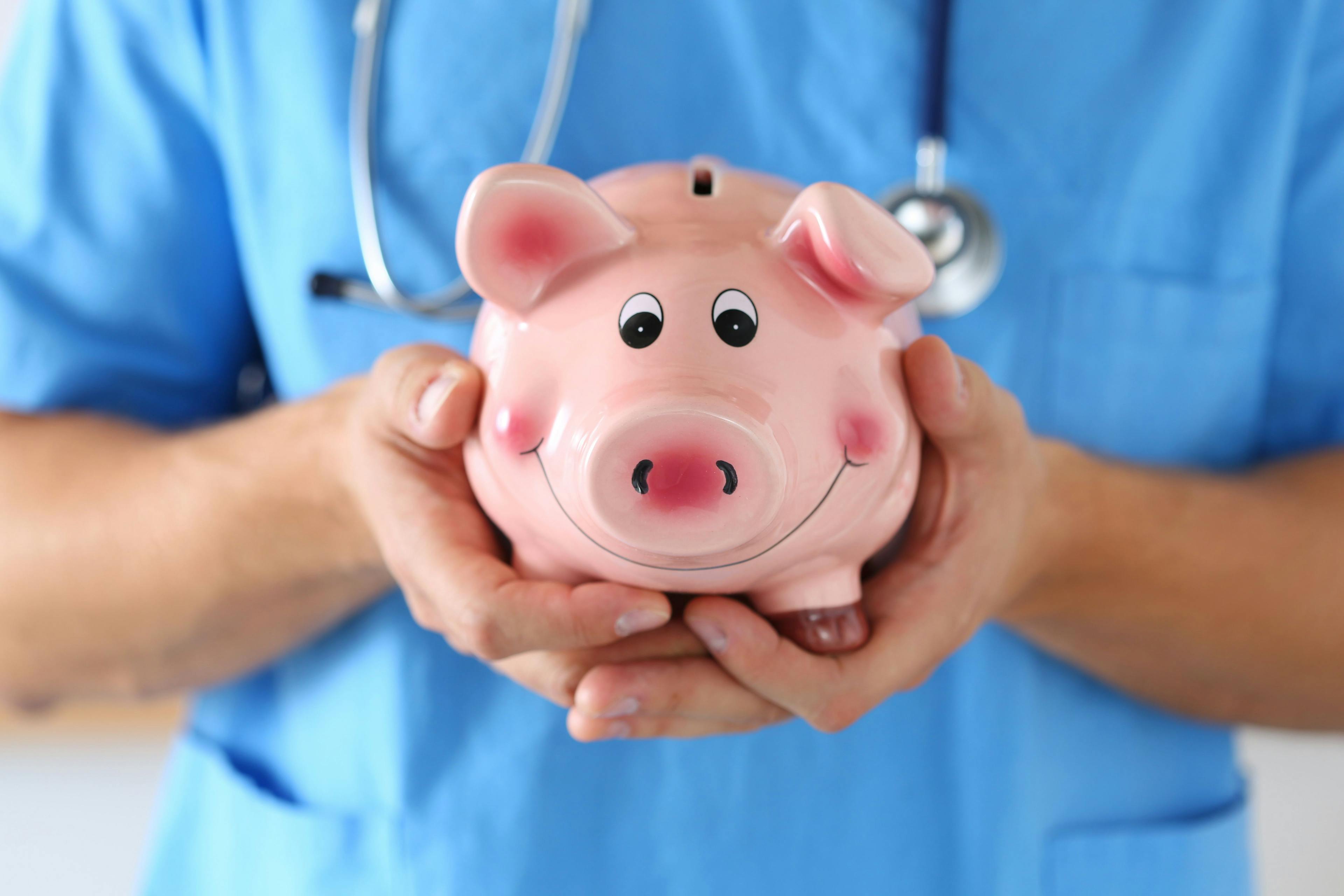 piggy bank held by doctor