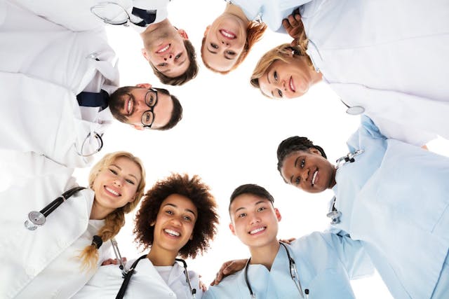 physicians doctors form happy huddle: © Andrey Popov - stock.adobe.com