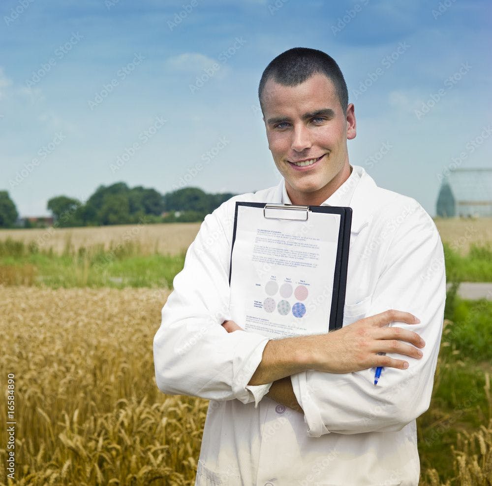 doctor holding medical chart with farm in background ©Noam-stock.adobe.com